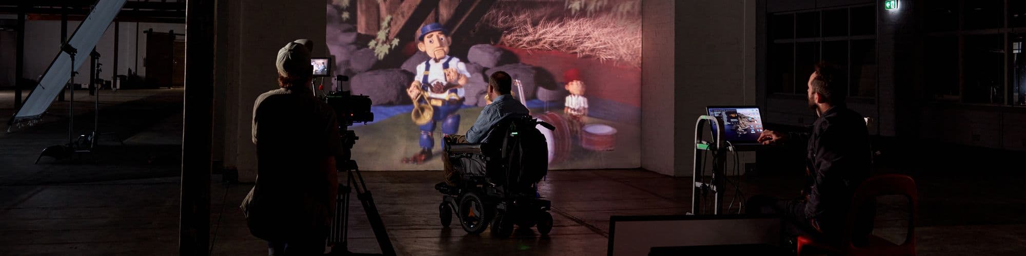 A wheelchair user watching a movie in a dark cinema and being filmed