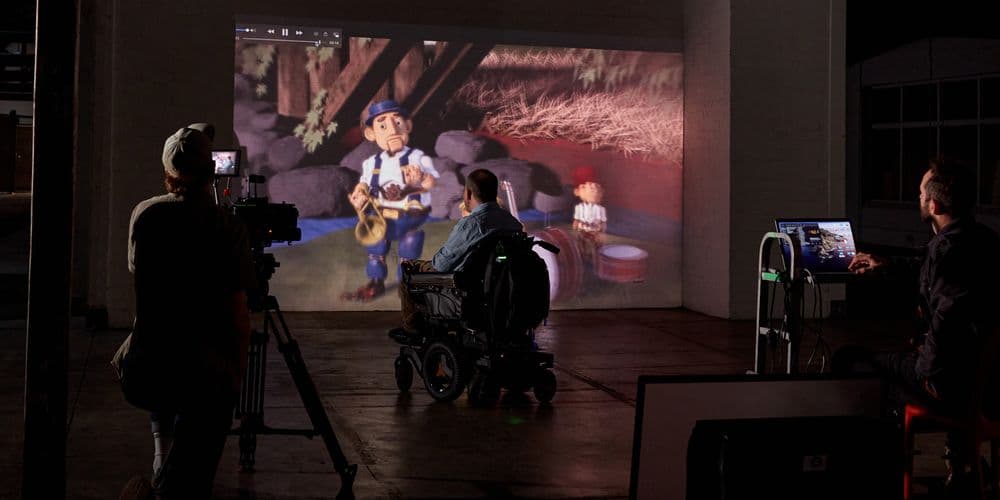 A wheelchair user watching a movie in a dark cinema and being filmed